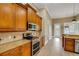 Kitchen featuring wood cabinets, stainless appliances and granite countertops at 2743 Verandah Vue Way, Lakeland, FL 33812