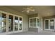 Covered patio with ceiling fan, double doors, and a window with shutters provides a cozy outdoor space at 2743 Verandah Vue Way, Lakeland, FL 33812