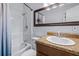 Bathroom with a tub/shower, oak vanity, and granite countertop; a large mirror enhances the space at 280 W Pierce St, Lake Alfred, FL 33850