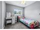Neutral bedroom with a ceiling fan, a large window, and a vanity desk against grey walls at 280 W Pierce St, Lake Alfred, FL 33850