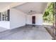 Spacious carport area with concrete flooring, side entry door and access to the front yard at 280 W Pierce St, Lake Alfred, FL 33850