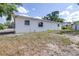 Exterior view of the home showing the lawn, trees, and white painted cinder block at 280 W Pierce St, Lake Alfred, FL 33850