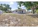 View of the single story home from the side yard featuring chain link fence and carport at 280 W Pierce St, Lake Alfred, FL 33850