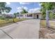 Charming single-story house featuring a fenced yard, spacious driveway, and covered carport at 280 W Pierce St, Lake Alfred, FL 33850