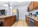 Galley-style kitchen with wood cabinets, granite countertops, stainless steel appliances, and neutral tile floors at 280 W Pierce St, Lake Alfred, FL 33850