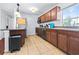 Galley-style kitchen with wood cabinets, granite countertops, stainless steel appliances, and neutral tile floors at 280 W Pierce St, Lake Alfred, FL 33850