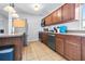 Galley-style kitchen with wood cabinets, granite countertops, stainless steel appliances, and neutral tile floors at 280 W Pierce St, Lake Alfred, FL 33850