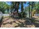 View of the backyard with mature trees showing the back of the house and fenced pool area at 2933 Blackwater Oaks Dr, Mulberry, FL 33860