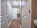 Hallway view of laundry room with white door, shelving and wood floors at 2933 Blackwater Oaks Dr, Mulberry, FL 33860