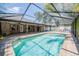 Enjoy this beautiful pool with a screened enclosure, brick paver deck, and a clear blue sky at 2933 Blackwater Oaks Dr, Mulberry, FL 33860