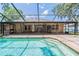 A screened enclosure with a brick paver deck encases this pool with a clear blue sky overhead at 2933 Blackwater Oaks Dr, Mulberry, FL 33860
