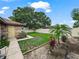 Private fenced backyard with a well-maintained lawn, tropical plants, and space for outdoor activities at 3002 Helms Dr, Auburndale, FL 33823