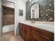 Charming bathroom with decorative wallpaper, a framed mirror and wood vanity at 3002 Helms Dr, Auburndale, FL 33823