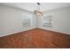 Cozy dining room featuring hardwood floors, two large windows, and modern chandelier at 3002 Helms Dr, Auburndale, FL 33823