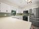 Modern kitchen featuring stainless steel appliances, quartz countertops, and green backsplash at 3002 Helms Dr, Auburndale, FL 33823