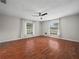 Spacious main bedroom with wood floors, ceiling fan, and bright windows at 3002 Helms Dr, Auburndale, FL 33823