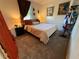 Cozy bedroom with carpet, draped window, artwork, side table with lamp, and a comfortable queen-sized bed at 3233 Gardner Rd, Lakeland, FL 33810