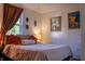 Bright bedroom with decorative wall art, soft lighting, a window, and a comfortable bed with pillows at 3233 Gardner Rd, Lakeland, FL 33810