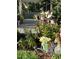 Lush front yard with blooming flowers and a cozy porch visible beyond garden decor at 3233 Gardner Rd, Lakeland, FL 33810