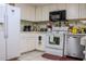 Well-lit kitchen features white cabinets, stainless steel appliances, and tile floors at 3233 Gardner Rd, Lakeland, FL 33810