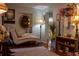 Comfortable living room area with hardwood floors, daybed, shelving, decorative mirror, and a standing lamp at 3233 Gardner Rd, Lakeland, FL 33810