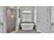 Bright bathroom featuring a modern tub, shower, and herringbone tile floor at 3822 Marquise Ln, Mulberry, FL 33860