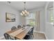 Dining area with stylish chandelier, wood table, and a large window at 3822 Marquise Ln, Mulberry, FL 33860