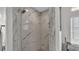 A glass-enclosed shower features a marble tiled surround and modern fixtures at 3822 Marquise Ln, Mulberry, FL 33860