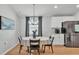 Bright dining room with modern light fixture, stainless fridge, and wood floors at 3946 Willow Ridge Dr, Lakeland, FL 33810