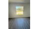 Well-lit room with a window looking outside and new wood floors at 4036 Oak Loop # 104, Mulberry, FL 33860