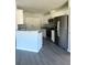 Modern kitchen features stainless steel appliances, a kitchen island, and white cabinetry at 4036 Oak Loop # 104, Mulberry, FL 33860