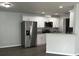 New kitchen with stainless steel appliances, white cabinets, and laminate floors at 4038 Oak Loop # 103, Mulberry, FL 33860