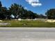 Roadside lot view with a grassy area, trees and some construction material bundles at 4038 Oak Loop # 103, Mulberry, FL 33860