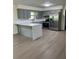 Well-lit kitchen featuring gray cabinets, stainless steel appliances, and a spacious island with quartz countertop at 4127 Grove Pl, Lakeland, FL 33810