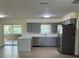 Modern kitchen featuring gray cabinets, stainless steel appliances, and an island with a light countertop at 4127 Grove Pl, Lakeland, FL 33810