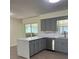 Modern kitchen features gray cabinets, stainless steel appliances, and an island with a white countertop at 4127 Grove Pl, Lakeland, FL 33810