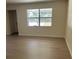 Cozy living room with view to front yard and featuring new flooring and neutral walls at 4127 Grove Pl, Lakeland, FL 33810