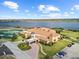 Aerial view of a resort-style clubhouse with tennis courts, lush landscaping, and serene lakeside views at 4193 Stone Creek Loop, Lake Wales, FL 33859