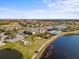 Aerial view of community amenities, including a pool, clubhouse, golf course, and picturesque lake at 4193 Stone Creek Loop, Lake Wales, FL 33859