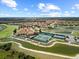 Aerial view of a residential community with a clubhouse, tennis courts, and scenic water features at 4193 Stone Creek Loop, Lake Wales, FL 33859