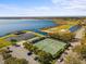 Aerial view featuring tennis courts, lake, and golf course showcasing community's recreational amenities at 4193 Stone Creek Loop, Lake Wales, FL 33859