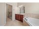 Elegant primary bathroom featuring granite counters, dark wood cabinets, separate shower and tub at 4193 Stone Creek Loop, Lake Wales, FL 33859