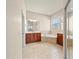 Open bathroom with a double sink vanity and shower, with neutral tile floors and recessed lighting at 4193 Stone Creek Loop, Lake Wales, FL 33859