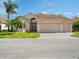 Charming home with a three-car garage, well-manicured lawn, and lush landscaping including mature palm trees at 4193 Stone Creek Loop, Lake Wales, FL 33859