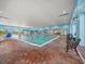 Inviting indoor swimming pool with blue walls, brick floors, and lots of space at 4193 Stone Creek Loop, Lake Wales, FL 33859