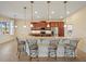 Open kitchen features a large breakfast bar, granite countertops, stainless steel appliances, and pendant lighting at 4193 Stone Creek Loop, Lake Wales, FL 33859