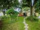 Serene backyard with a stone pathway, vibrant greenery, hot tub, and a cozy outdoor seating area at 427 Longfellow Blvd, Lakeland, FL 33801