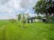 Outbuildings in a backyard on a grassy lot with trees and a glimpse of the water in the distance at 427 Longfellow Blvd, Lakeland, FL 33801