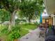 Backyard featuring lush greenery, mature trees, outdoor seating, and a glimpse of the home's exterior at 427 Longfellow Blvd, Lakeland, FL 33801