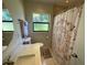 Neutral bathroom featuring a shower with a patterned curtain, a functional frosted window, and towel racks at 427 Longfellow Blvd, Lakeland, FL 33801